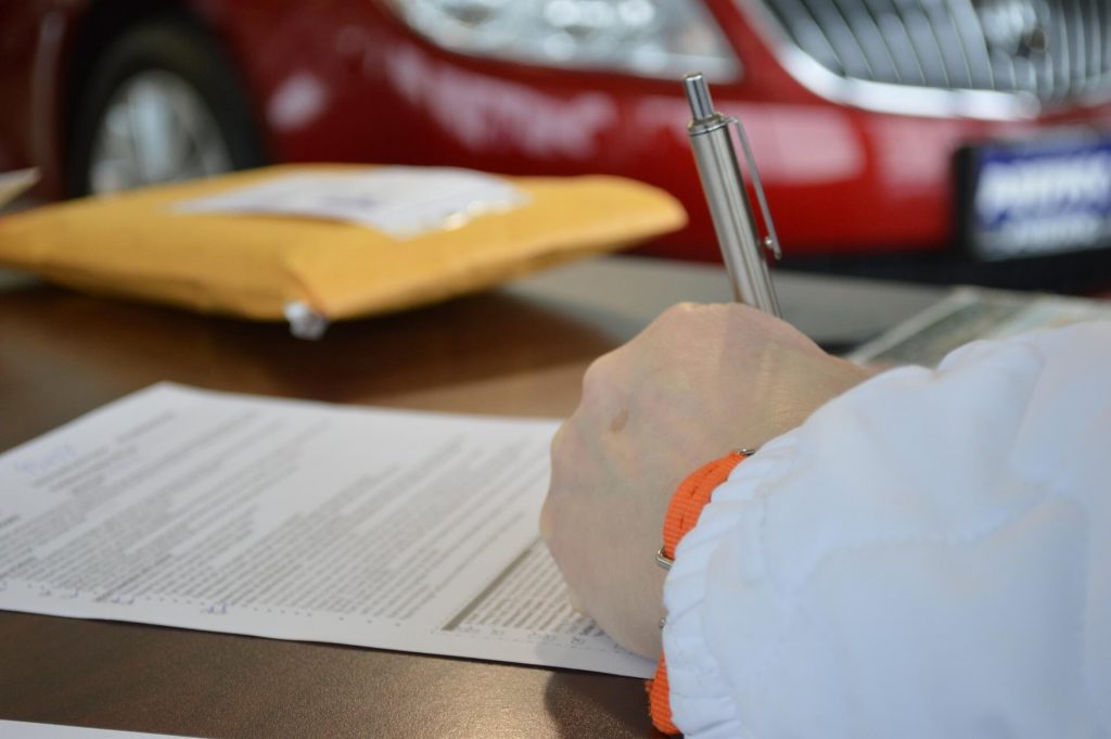 Man signing title loan agreement